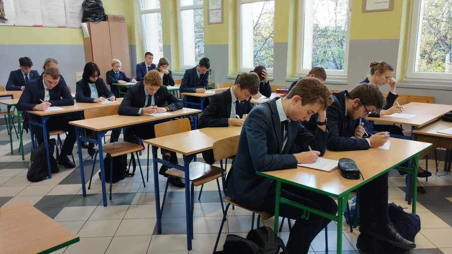 Uczniowie w sali lekcyjnej piszący dyktando