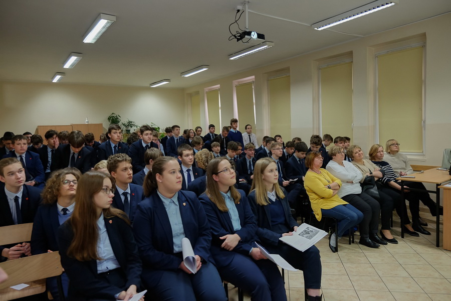 Sala lekcyjna wypełniona uczniami, w pierwszym rzędzie nauczycielki i dyrekcja