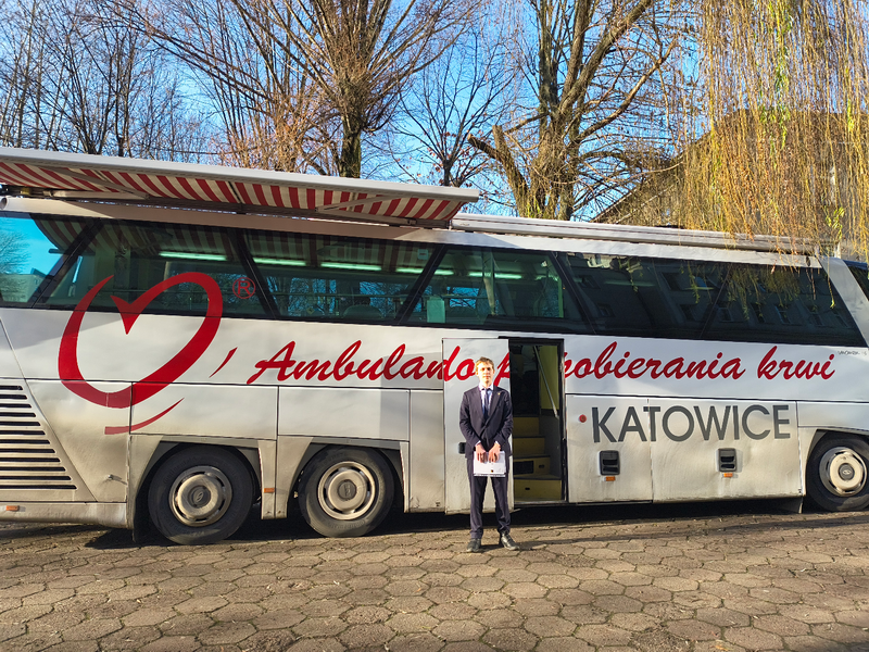 ulans stacji krwiodawstwa przed budynkiem szkoły, na jego tle uczeń