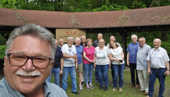 Pamiątkowe zdjęcie, w tle napis „50 lat po maturze”; z lewej strony na pierwszym planie Janusz, dalej: Bogdan (tylko połowa), Waldek, Andrzej, Jurek, Piotr, Urszula, Stenia, Marian, Iwona, Włodek, Zdzisiek, Krzysiek