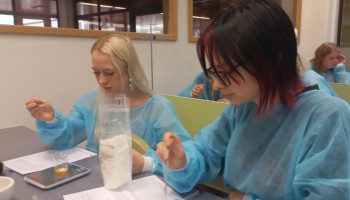 2 uczennice w skupieniu odmierzają proporcje do kremu