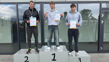 Na podium zwycięzcy biegu na 1500 m, w środku Michał Gaweł – 1. miejsce, z medalem i dyplomem