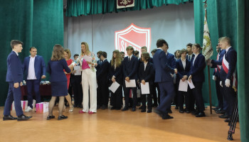 Uczniowie wychodzący na scenę, gdzie otrzymują certyfikaty