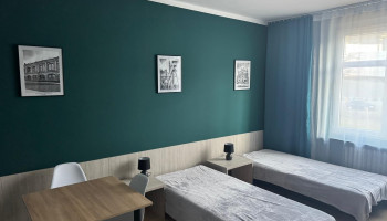 Pokój gościnny – przestrzeń noclegowa z łóżkami oraz stolikiem dla wygody gości.