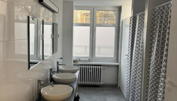 Łazienka – nowoczesne zaplecze sanitarne z prysznicami, umywalkami i lustrami.