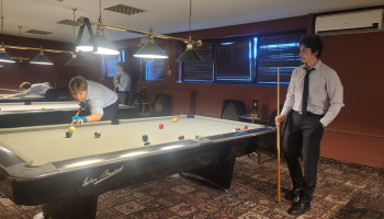 Uczniowie w klubie bilardowym wokół stołu