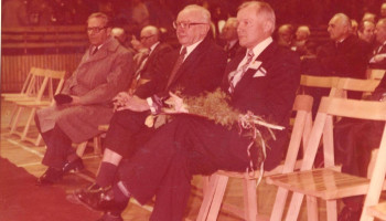 Dyrektor S. Kibica z wiązanką kwiatów, obok były Dyrektor Jerzy Czupryna – siedzą w I rzędzie (kolorowe zdjęcie)