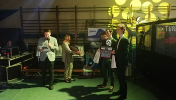 Dwóch uczniów odbierający dyplom podczas uroczystości wręczania nagród