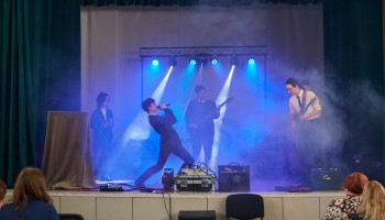 popis wokalno-taneczny występującego ucznia, akompaniuje zespół: 3 gitarzystów i perkusista 