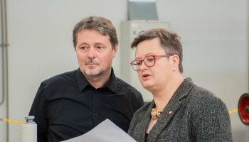 nauczyciel praktycznej nauki zawodu objaśnia pani minister instrukcję/rysunek do pracy na tokarce