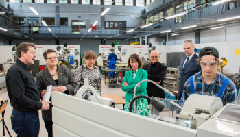 goście i nauczyciele obserwują pracę ucznia na tokarce