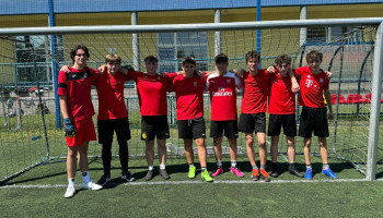 drużyna 1E – 2 miejsce – drużyna 8 uczniów w czerwonych koszulkach na tle bramki boiska Hetman