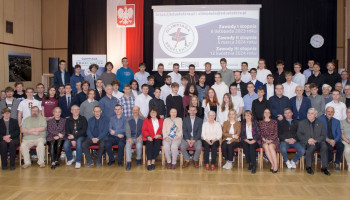 Opiekunowie i uczestnicy finału Olimpiady Wiedzy o Elektrotechnice i Energetyce EDU-ELEKTRA w Ostrowie Wielkopolskim. Zdjęcie grupowe na auli, w której odbywał się finał Olimpiady. Michał Mansfeld stoi w drugim rzędzie ósmy od lewej. Opiekun, Maciej Czakański, siedzi w pierwszym rzędzie, trzeci od prawej.