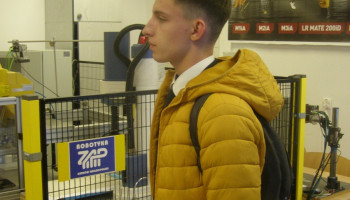 Zawody finałowe Olimpiady Wiedzy Elektrycznej i Energetycznej EUROELEKTRA. Politechnika Opolska 25.04.2024. Zwiedzanie pracowni robotyki politechniki. Na pierwszym planie Michał Mansfeld.