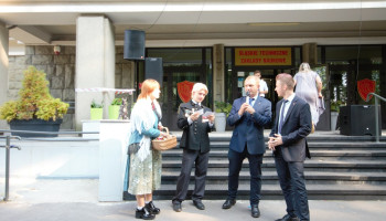 kolejny uczestnik konkursu, uczeń w stroju górniczym czyta pytanie, nauczyciel w środku z mikrofonem, z lewej uczennica w stroju śląskim trzyma koszyk