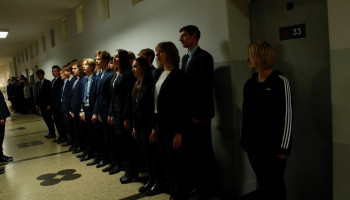 uczniowie innej klasy i nauczyciel podczas śpiewania hymnu na I piętrze szkoły
