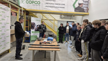 Pracownik prezentuje firmę zwiedzającym uczniom