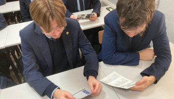 dwaj uczniowie czytają ulotkę informacyjną o pracy CBZC