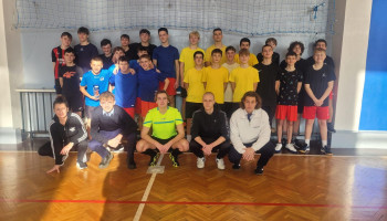 zdjęcie grupowe: drużyny klas (na stojąco, w drugim rzędzie), pierwszy rząd – kucają od lewej organizatorka turnieju, pomocnicy, w środku sędzia (w żółtej koszulce)