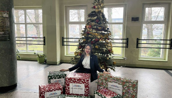 uczennica Bożena, aktywnie zaangażowana w akcję, z darami, w tle świąteczna choinka