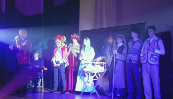 betlejemska stajenka, obok żłóbka – od prawej: pasterze, Józef, Maryja, królowie; ks. Adrian składa życzenia świąteczne